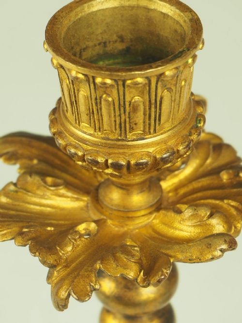fig 1. A pair of nineteenth-century French gilt bronze candlesticks featuring acanthus leaf scroll bases, beaded stems, and fluted sconces.