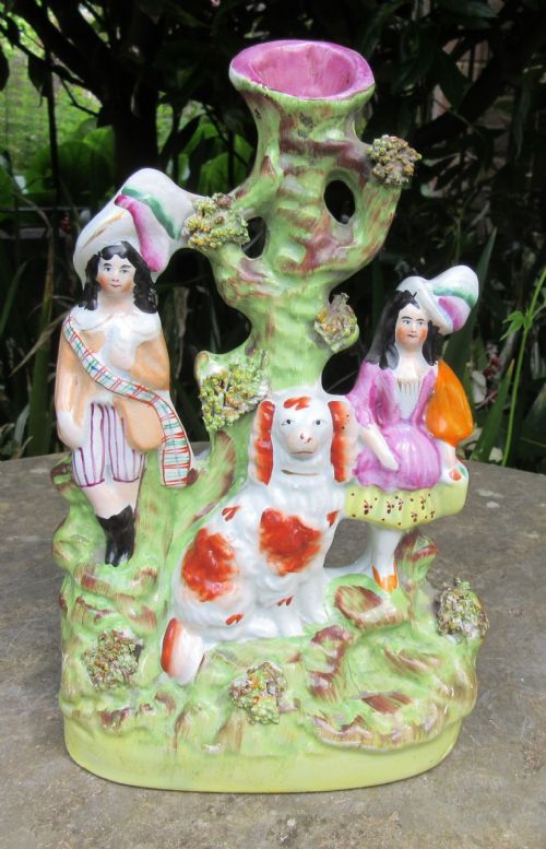 fig 1. A pair of 19th-century Victorian Staffordshire earthenware spill vases featuring hand-painted figures, spaniels, and hollow tree trunk forms.