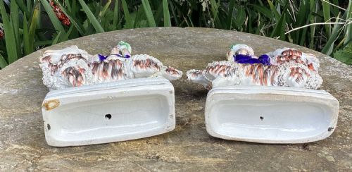 fig 1. A pair of Victorian Staffordshire earthenware figures showing figures seated on long-haired goats with hand-painted enamel decoration.