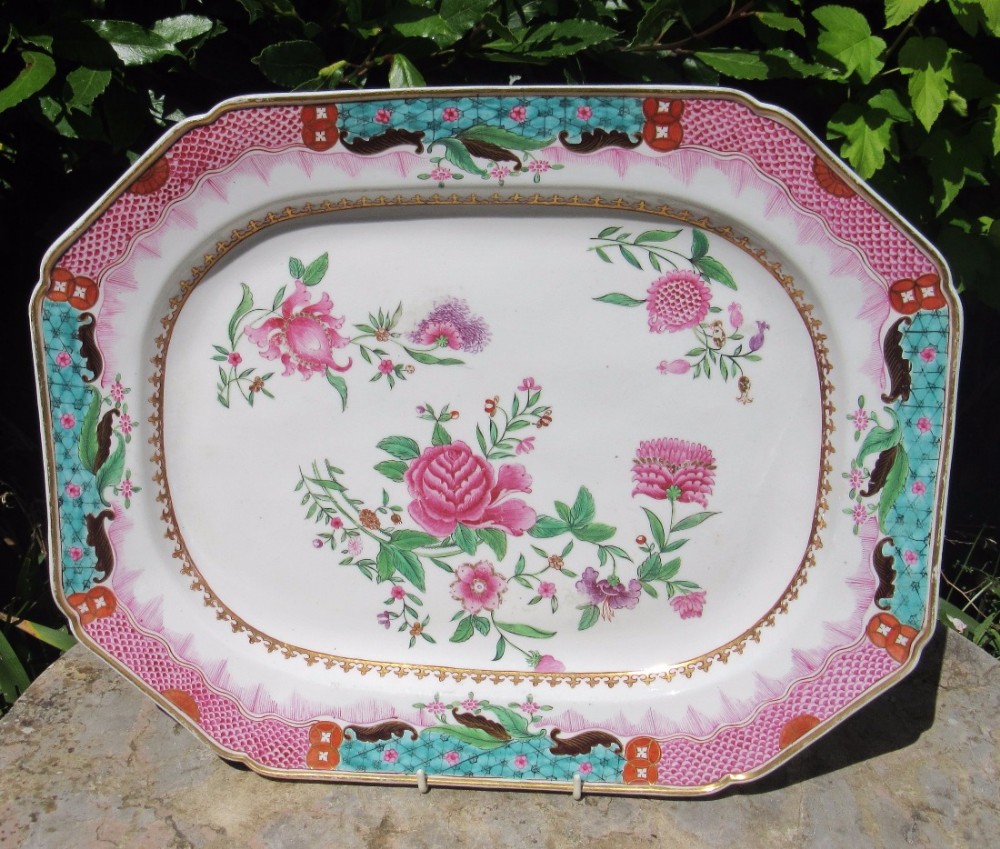 An octagonal white Georgian porcelain serving platter featuring hand-painted pink floral motifs, green foliage, and a pink and turquoise patterned rim.