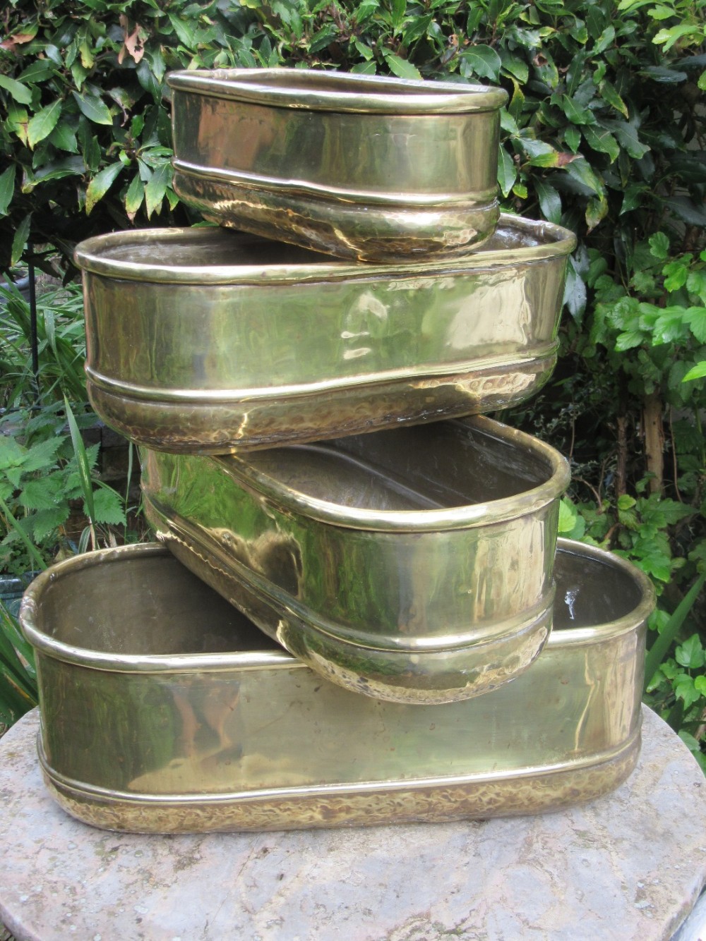 SET OF FOUR GRADUATED 1920s BRASS PLANTERS
