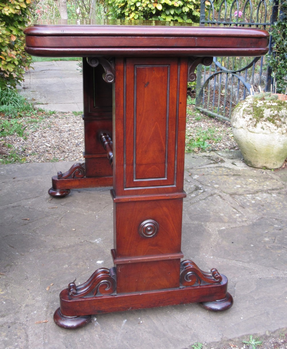 A William IV mahogany metamorphic serving table featuring a smooth rectangular top supported by panelled pedestal ends and a turned central stretcher. View IV