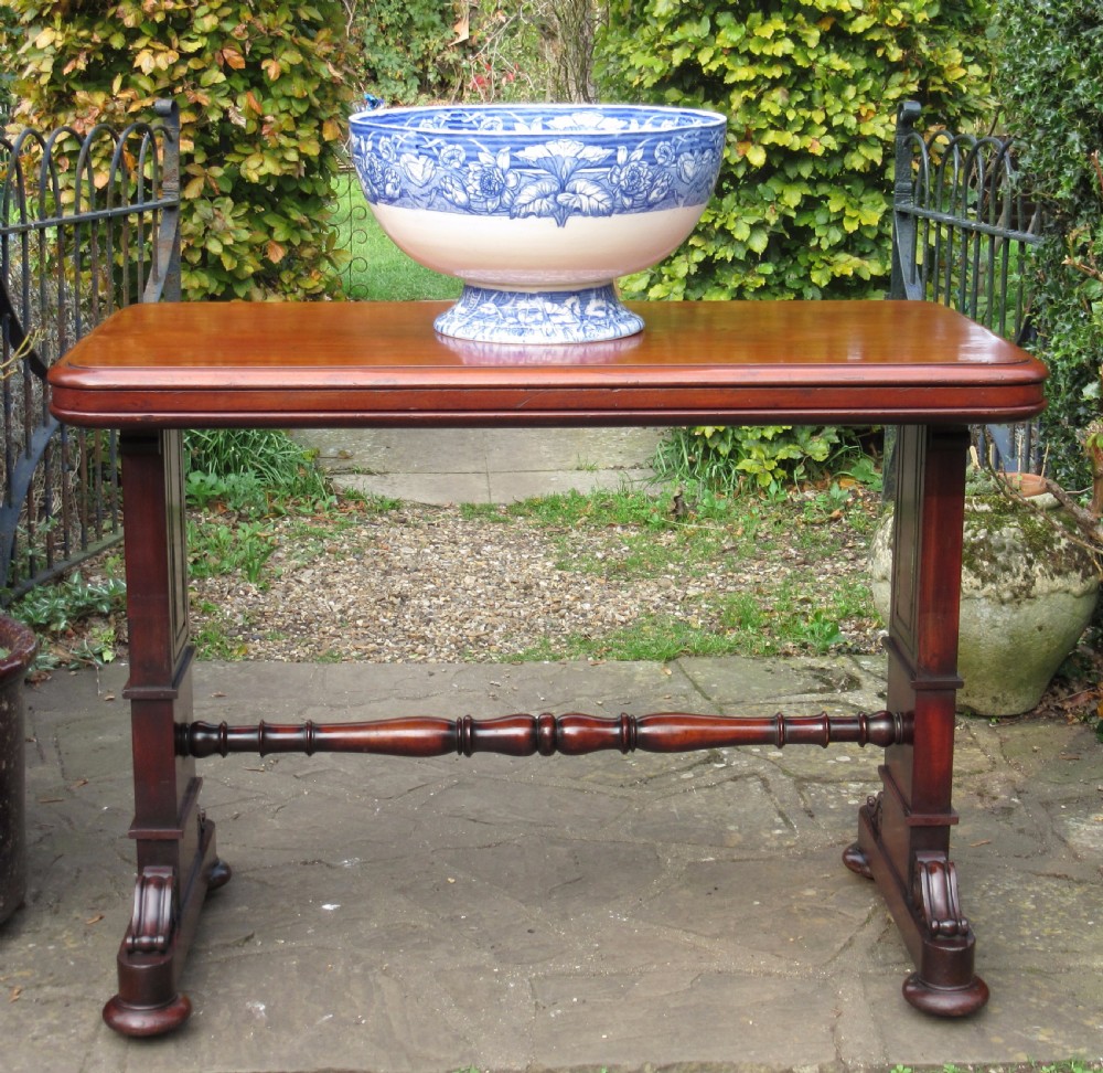 A William IV mahogany metamorphic serving table featuring a smooth rectangular top supported by panelled pedestal ends and a turned central stretcher. View VIII