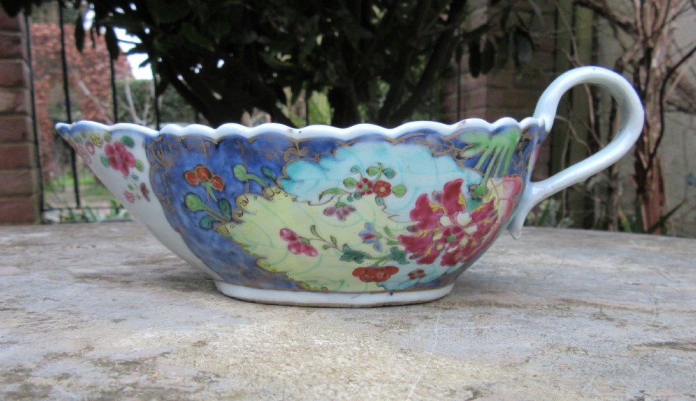 An 18th-century Chinese export porcelain sauceboat decorated in the Tobacco Leaf pattern with a loop handle and scalloped rim.