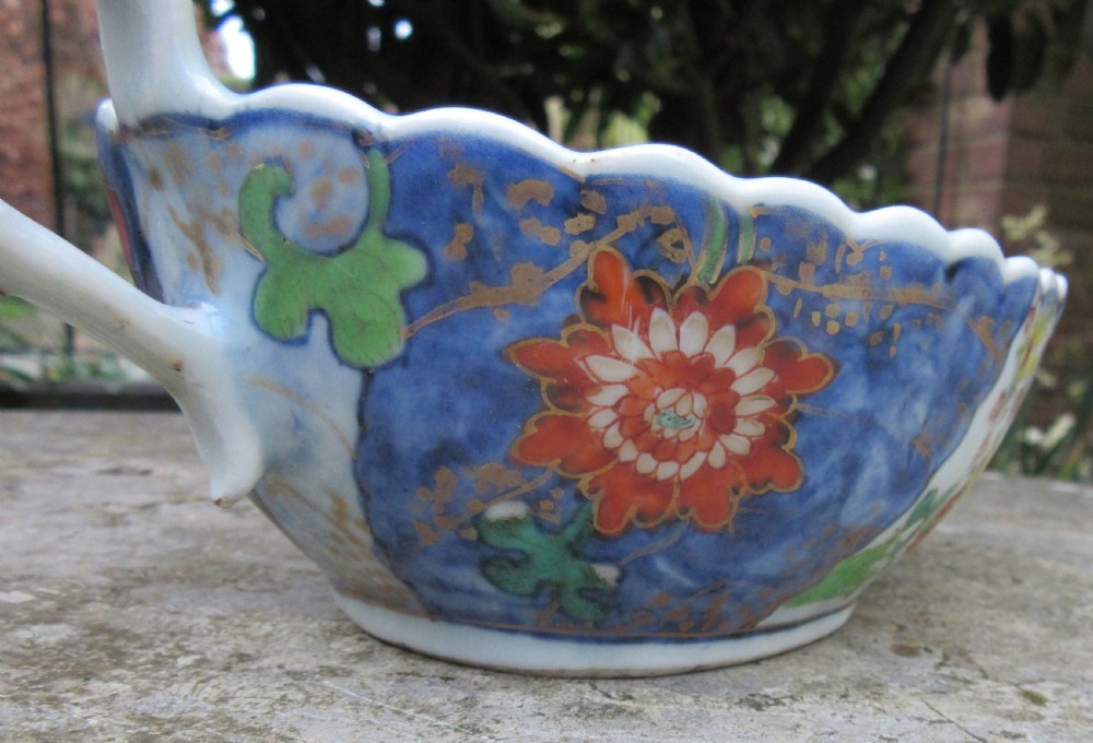 An 18th-century Chinese export porcelain sauceboat decorated in the Tobacco Leaf pattern with a loop handle and scalloped rim. View IV