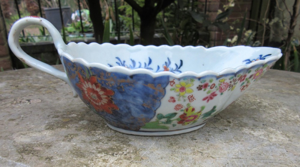An 18th-century Chinese export porcelain sauceboat decorated in the Tobacco Leaf pattern with a loop handle and scalloped rim. View VII
