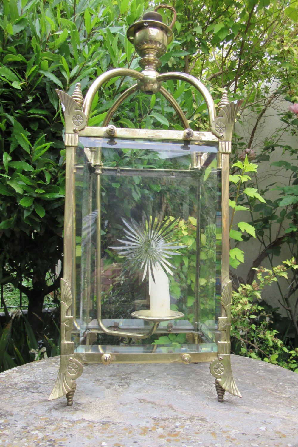 An English late 19th-century brass hall lantern with bevelled glass panels featuring starburst engravings and an arched top structure.