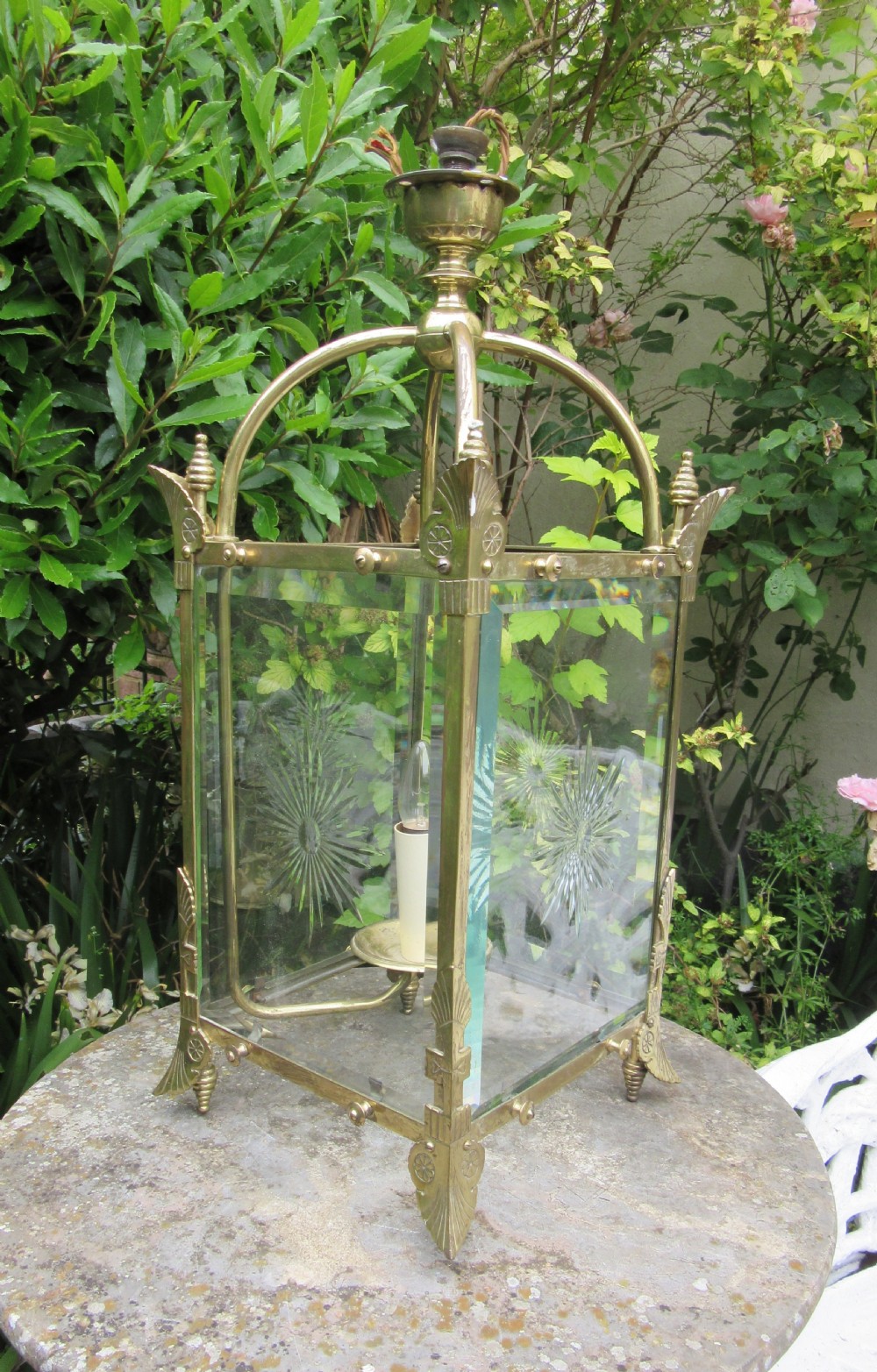 An English late 19th-century brass hall lantern with bevelled glass panels featuring starburst engravings and an arched top structure. View II