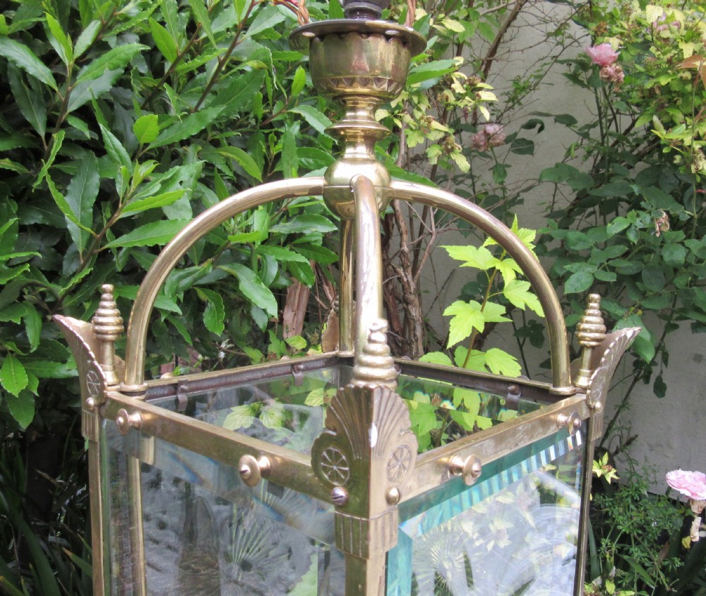 An English late 19th-century brass hall lantern with bevelled glass panels featuring starburst engravings and an arched top structure. View III
