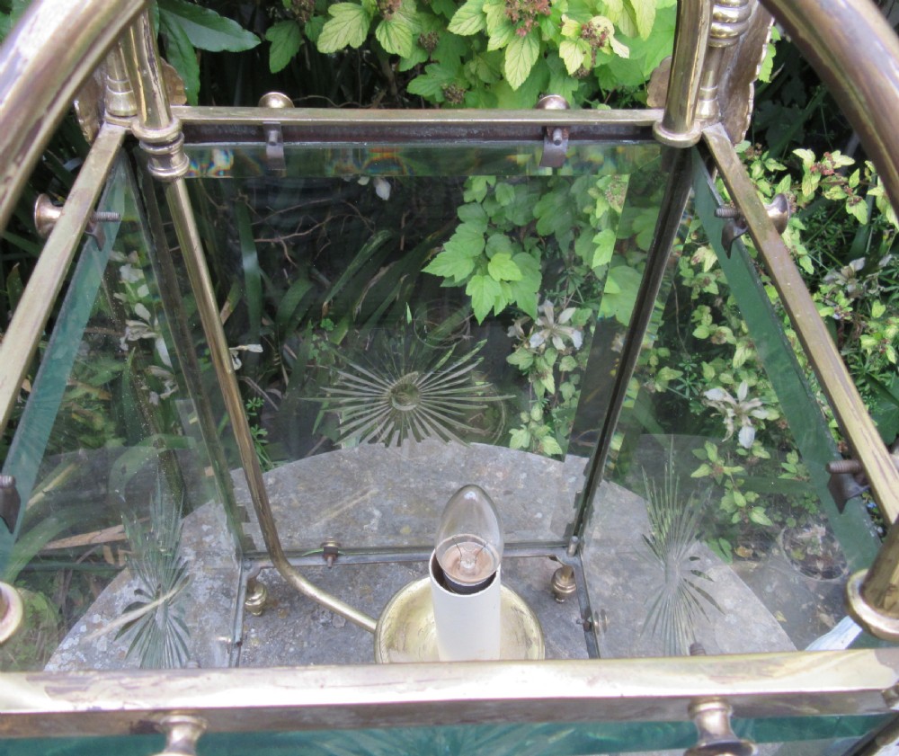 An English late 19th-century brass hall lantern with bevelled glass panels featuring starburst engravings and an arched top structure. View V