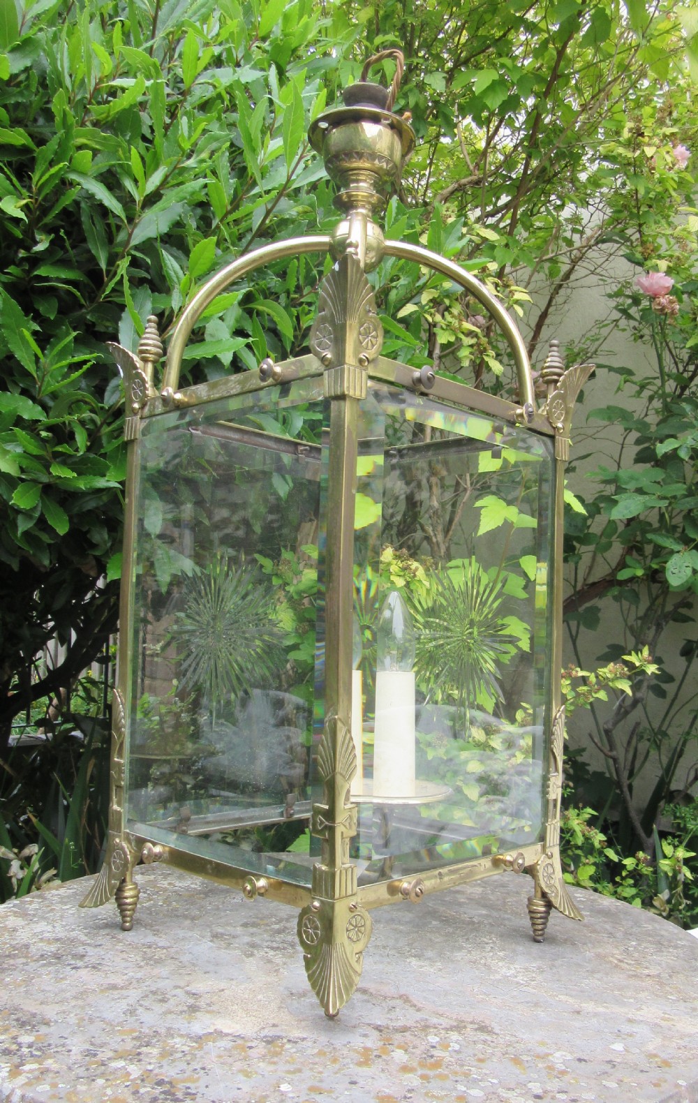 An English late 19th-century brass hall lantern with bevelled glass panels featuring starburst engravings and an arched top structure. View VI
