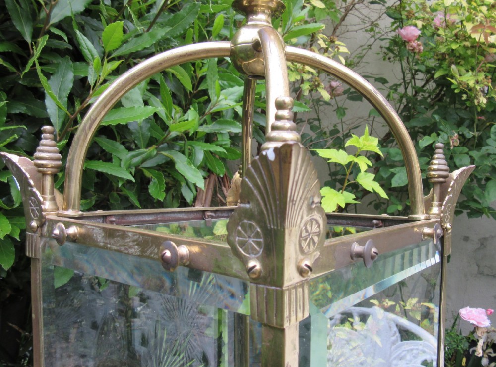 An English late 19th-century brass hall lantern with bevelled glass panels featuring starburst engravings and an arched top structure. View VII