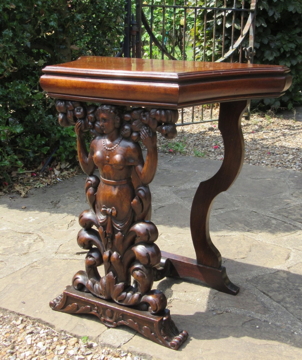 An antique Italian carved walnut pier table featuring a shaped top above a central carved caryatid figure resting on a scrolled base. View II