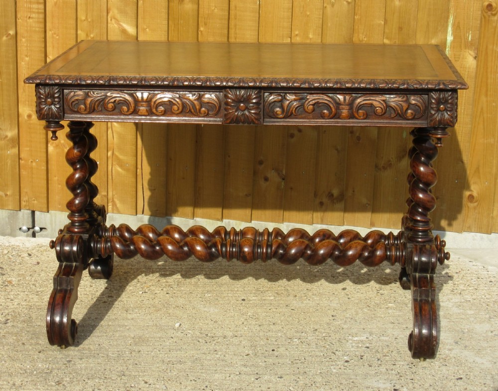 A late 19th-century dark oak writing table featuring relief-carved drawer fronts, barley twist legs, and a double twisted stretcher. View II