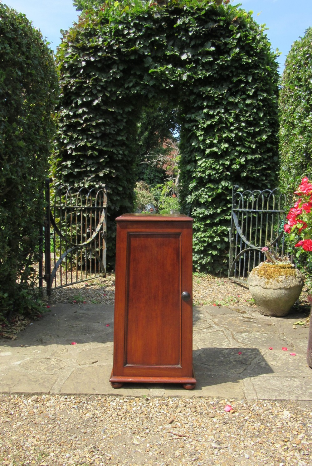 An early nineteenth-century mahogany pedestal cupboard with a single recessed panel door and a turned wooden knob. View IV