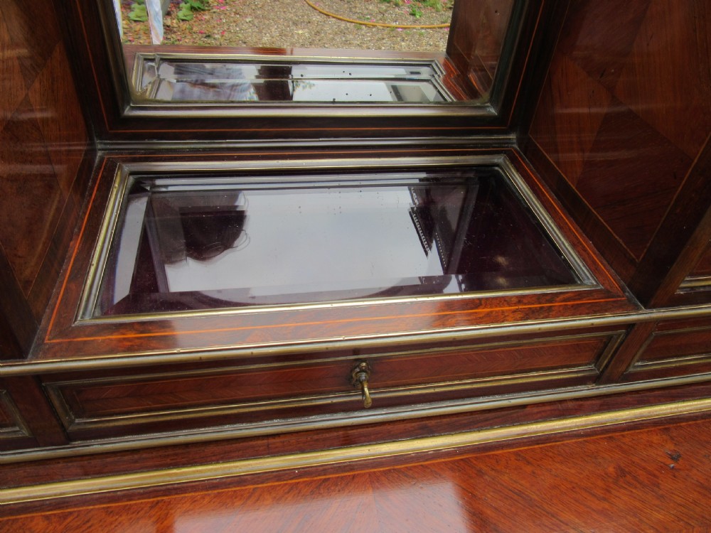 A late 19th-century rosewood bonheur du jour writing desk featuring brass gallery railings, an arched central mirror, multiple small drawers, and tapered legs. View III