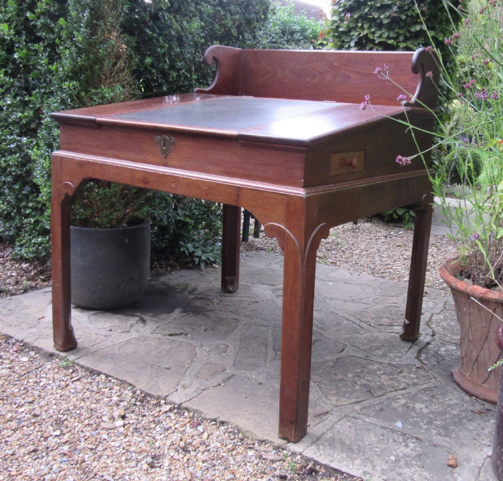 A Georgian mahogany estate desk featuring a slanted writing surface with a dark inset leather skiver, raised scrolled gallery back, and square legs with decorative corner spandrels. View III