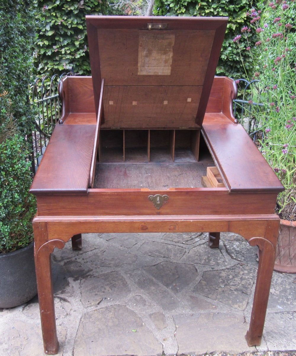 A Georgian mahogany estate desk featuring a slanted writing surface with a dark inset leather skiver, raised scrolled gallery back, and square legs with decorative corner spandrels. View IV