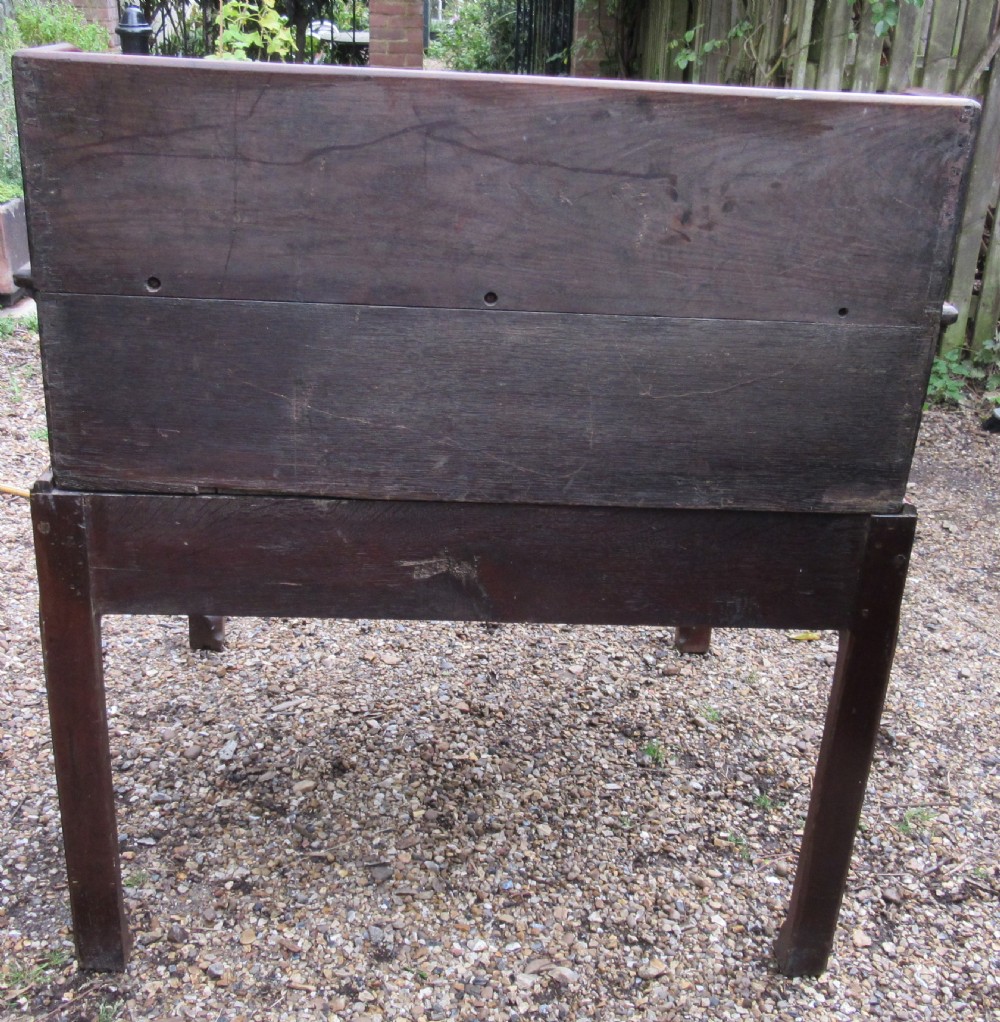 A Georgian mahogany estate desk featuring a slanted writing surface with a dark inset leather skiver, raised scrolled gallery back, and square legs with decorative corner spandrels. View VII