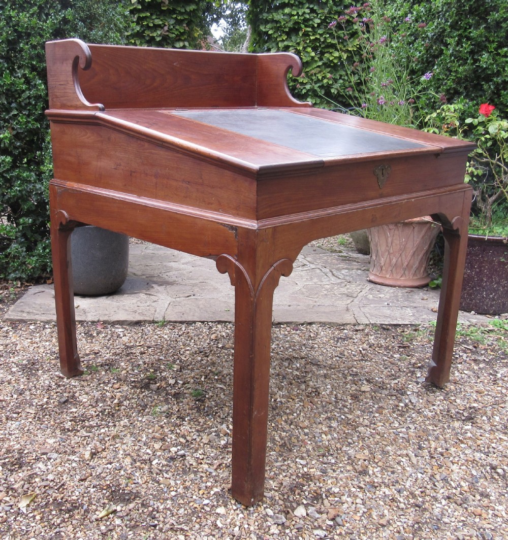 A Georgian mahogany estate desk featuring a slanted writing surface with a dark inset leather skiver, raised scrolled gallery back, and square legs with decorative corner spandrels. View XI