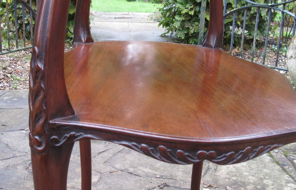 An Edwardian mahogany lamp table featuring a serpentine-shaped top, lower shelf, and four slender cabriole legs with carved detail. View VI