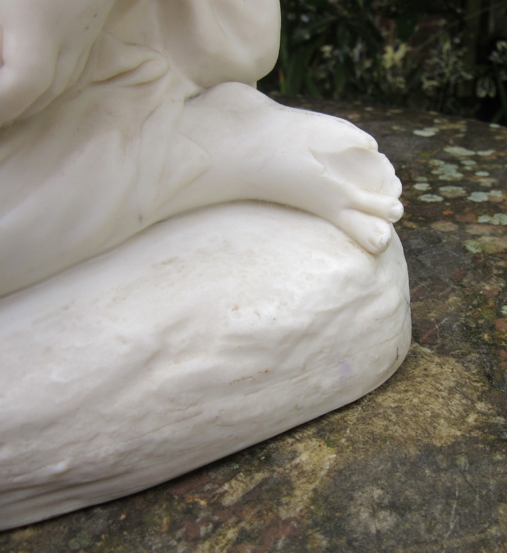 A white unglazed Parian porcelain sculpture depicting two young children sitting beside a sleeping cat on a naturalistic rock base. View VIII