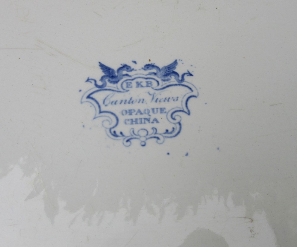 An oval earthenware platter featuring a blue and white printed Chinoiserie scene, surrounded by a floral scroll border with a moulded rim. View III