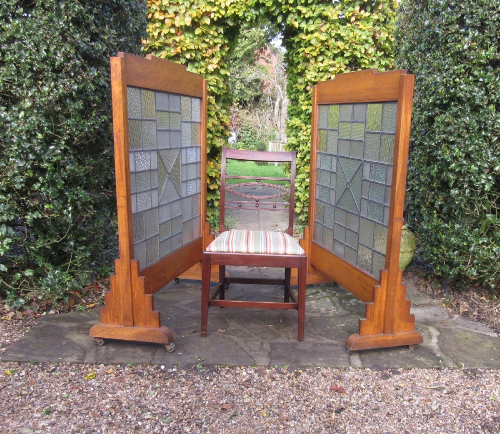 A pair of Art Deco medium oak screens featuring geometric leaded textured glass panels and stepped feet. View II