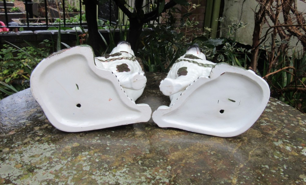 A pair of Victorian ceramic Staffordshire spaniel figurines featuring white glazed bodies with painted faces and copper lustre spots, ears, and moulded chains. View IV