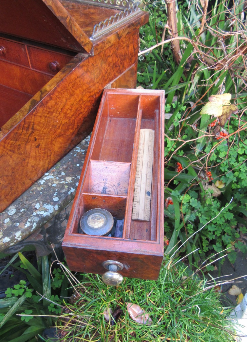 An antique Victorian figured walnut writing slope featuring a brass gallery rail and a brown leather writing surface with decorative gold tooling. View VI