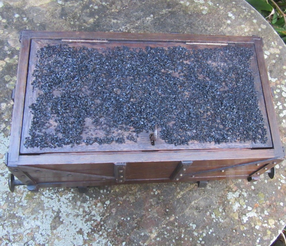 A late Victorian oak humidor designed in the form of a miniature railway coal wagon with metal wheels, buffers, and brass studs. View V