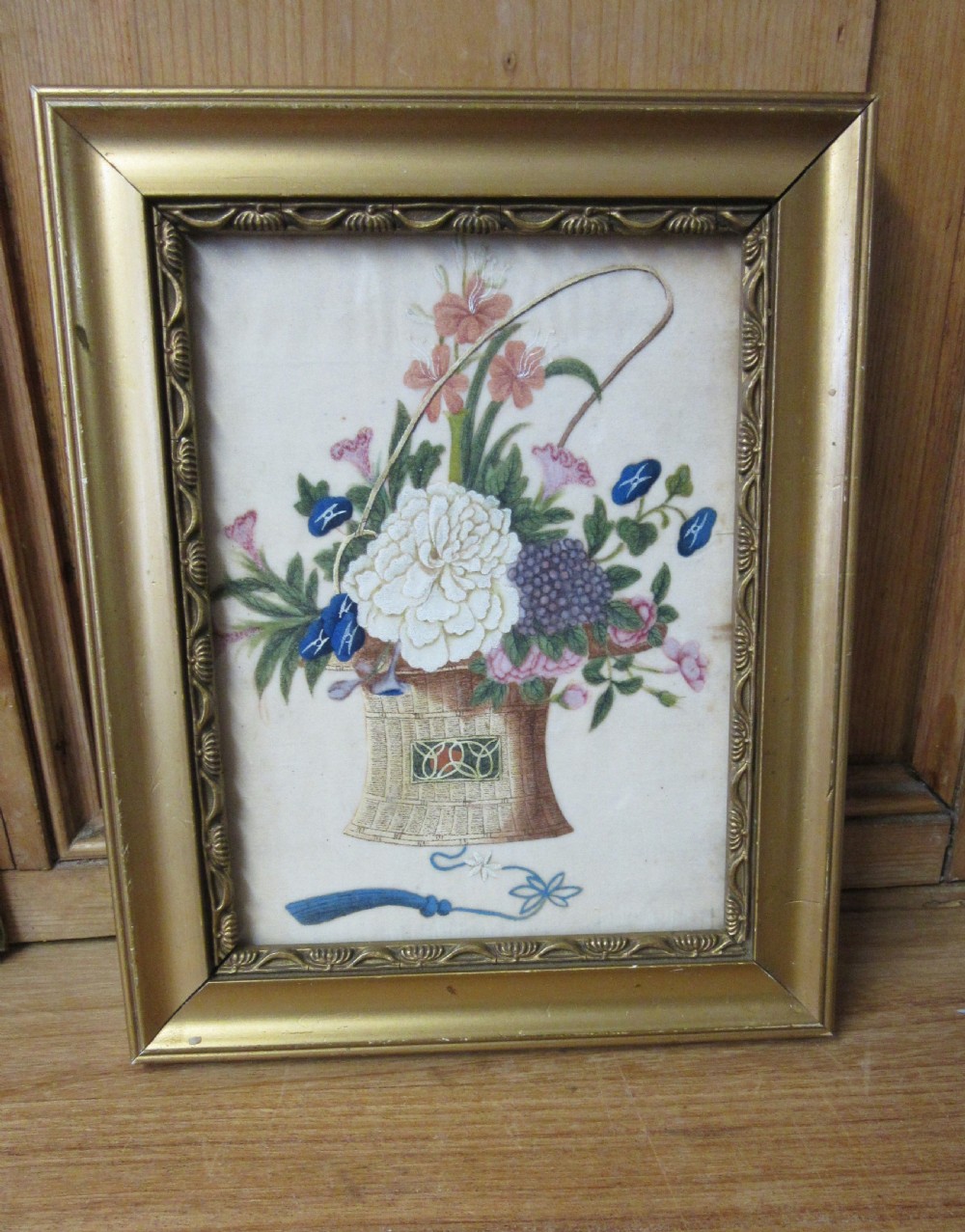 A 19th-century Chinese painting showing a woven basket filled with flowers inside a moulded gilt frame.