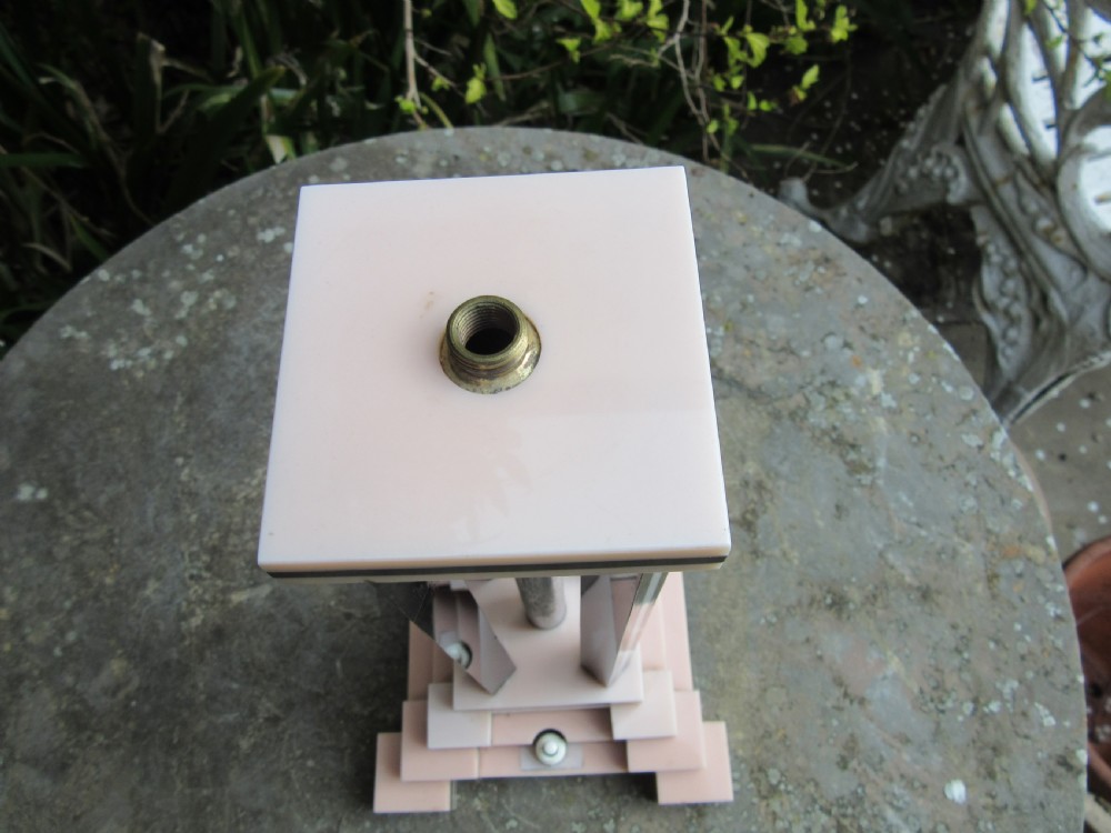 An Art Deco table lamp base featuring a stepped ziggurat foundation and vertical black and pink layered columns. View IV