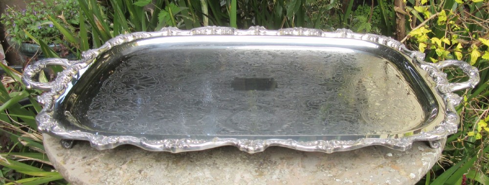A rectangular Victorian silver-plated tray featuring engraved foliate scrollwork, a shell motif border, and twin cast handles. View II