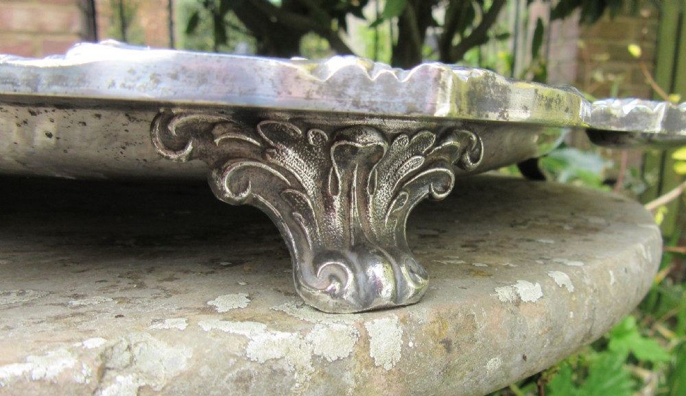 A rectangular Victorian silver-plated tray featuring engraved foliate scrollwork, a shell motif border, and twin cast handles. View VII