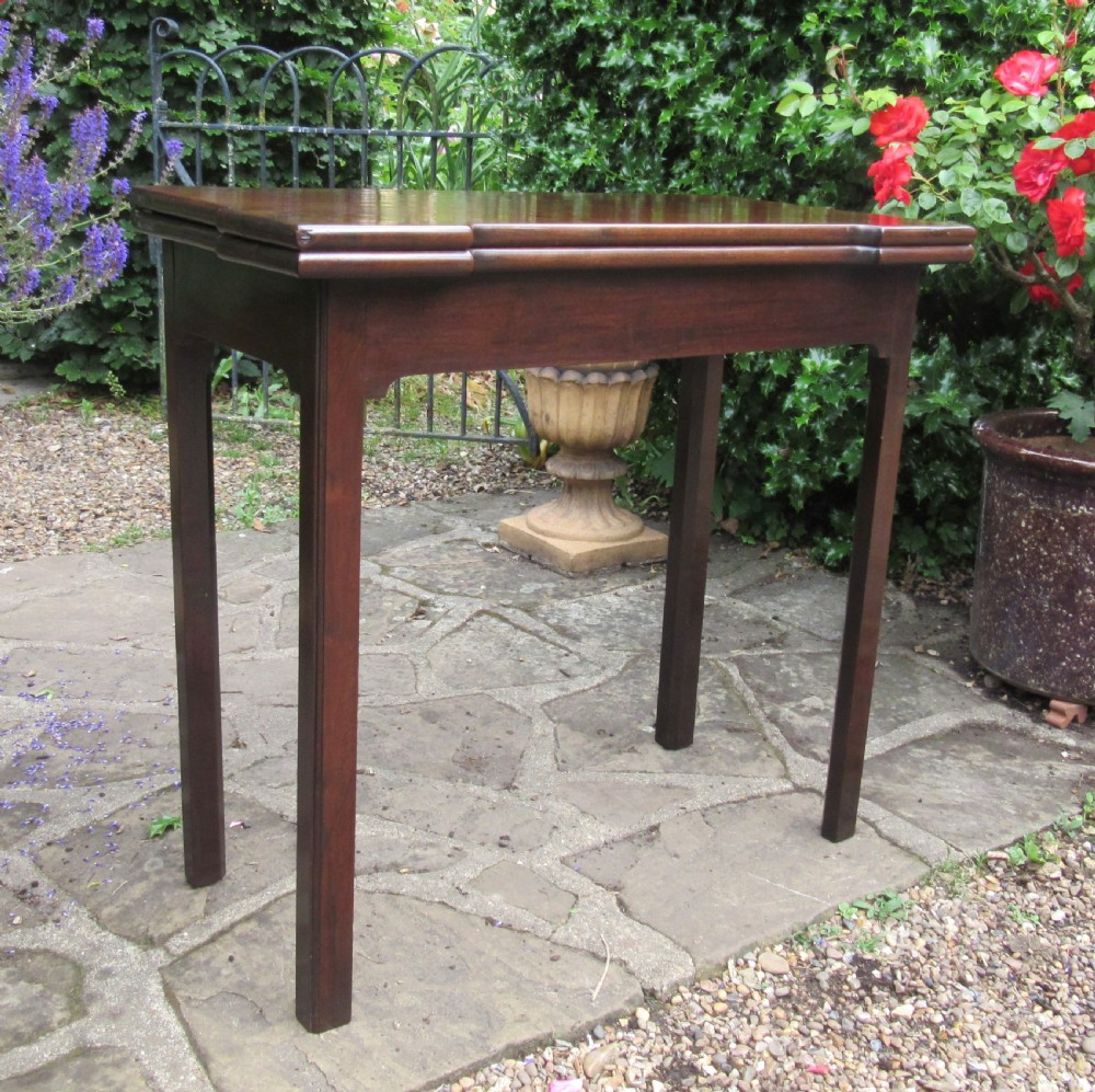A Georgian mahogany fold-over card table with shaped outset corners and four square straight legs. View III