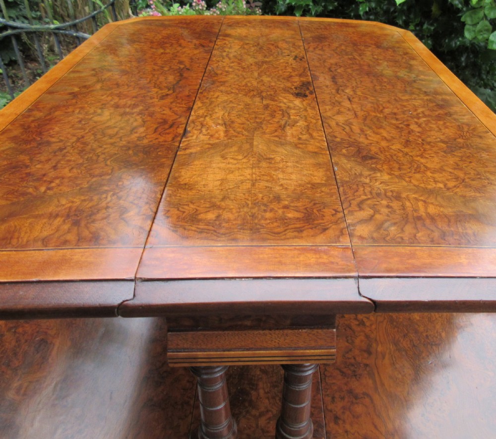 A two-tier Victorian burr walnut Sutherland tea table with folded drop leaves and turned spindle supports. View V