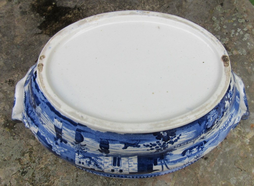 An antique 1830 Staffordshire earthenware tureen featuring blue and white Chinoiserie transferware decoration with a matching lid and side handles. View V