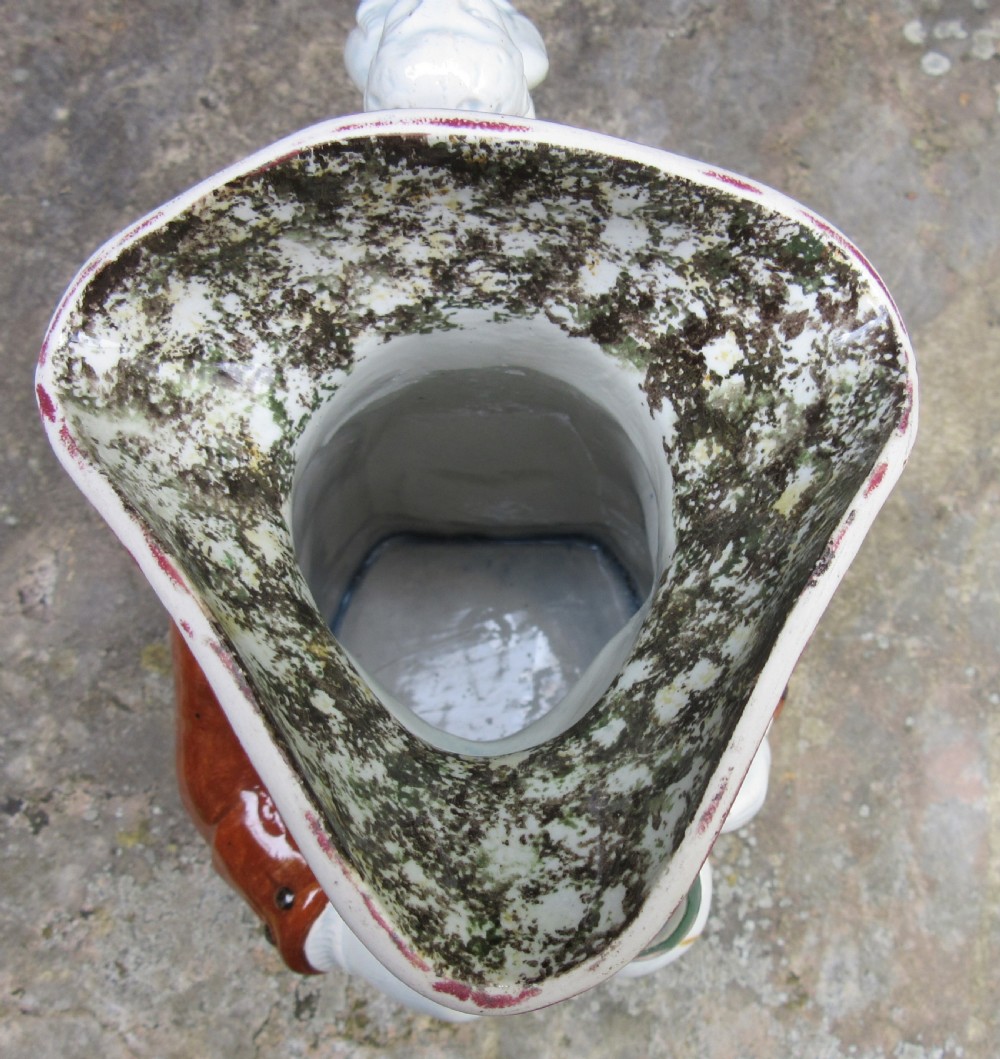 An antique early 19th-century English ceramic Toby jug depicting a seated man in a tricorn hat, brown coat, and blue breeches. View VIII