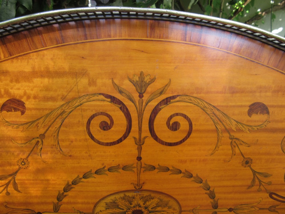 An oval satinwood serving tray featuring detailed central floral marquetry inlay, a pierced brass gallery rim, and two brass handles. View III