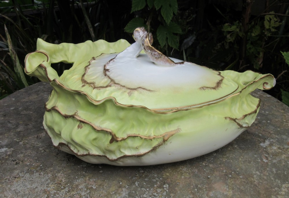 A Victorian Staffordshire ceramic soup tureen with lid, moulded in the shape of cabbage leaves with a pale green wash and gilded leaf rims.