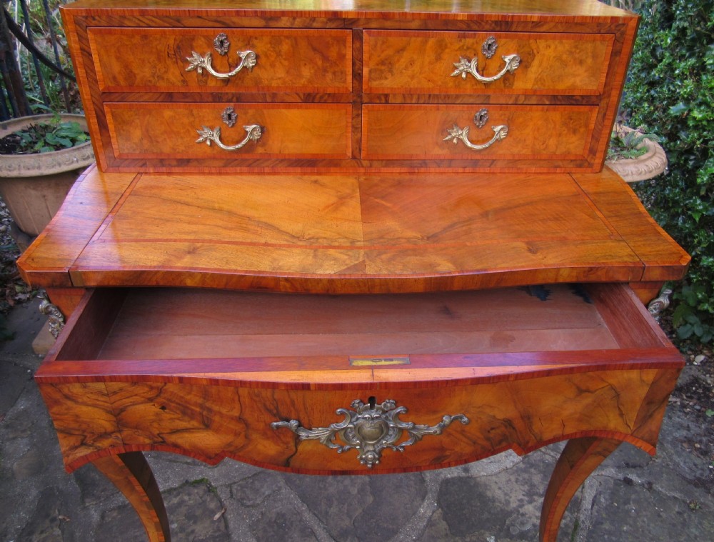 A figured walnut writing desk featuring a raised rear section with four drawers, slender cabriole legs, and decorative brass mounts. View VII
