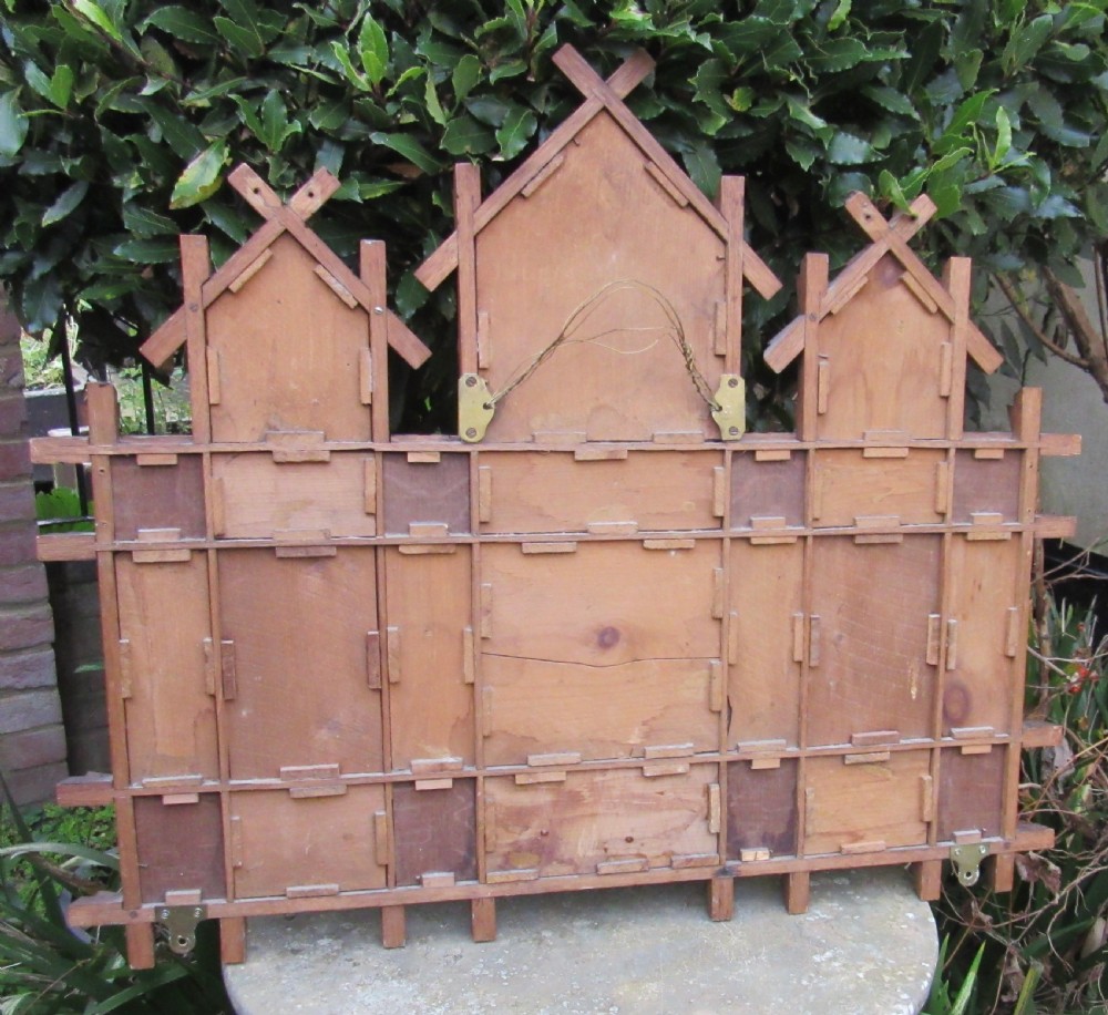 A Victorian Oxford Movement carved oak wall mirror featuring three gabled crests, a cross-hatched lattice structure, and multiple bevelled mirror plates. View IV