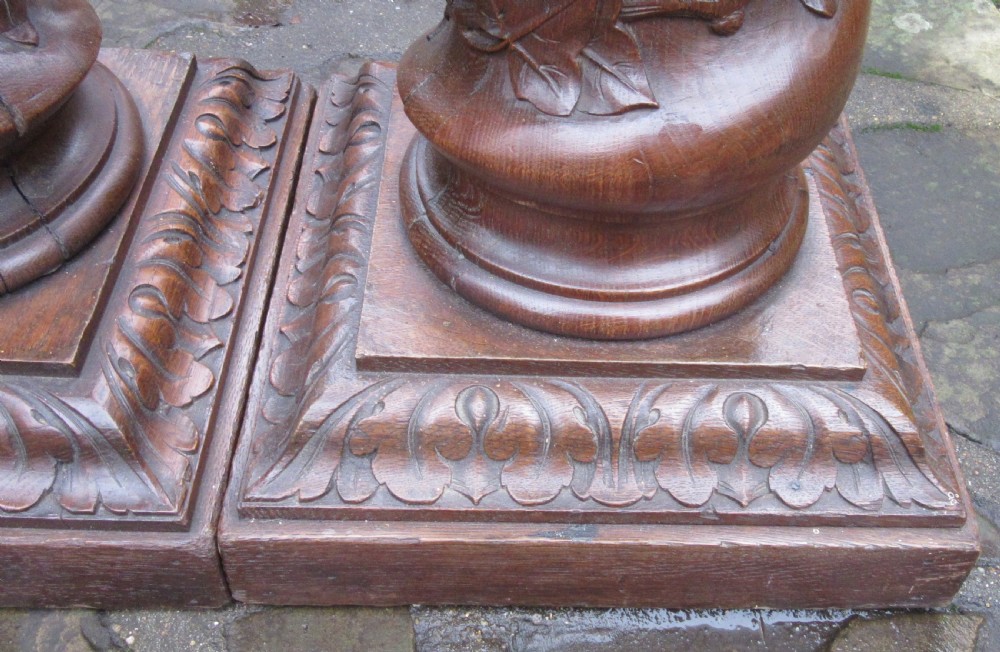 A pair of carved oak spiral column pedestals featuring acanthus leaf capitals, foliage relief carving, and square stepped plinth bases. View VI
