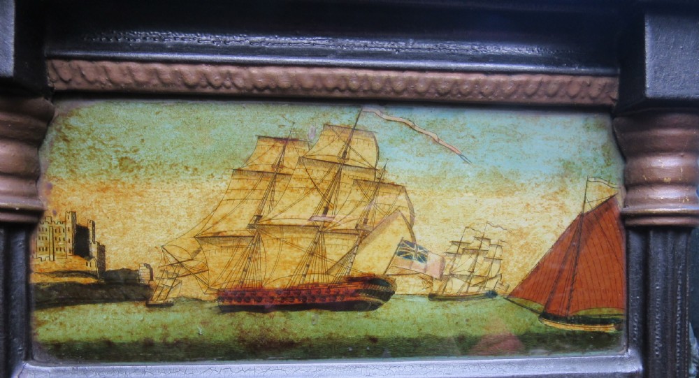 A rectangular Georgian ebonised wall mirror featuring fluted side pilasters and an upper painted panel depicting sailing ships. View II