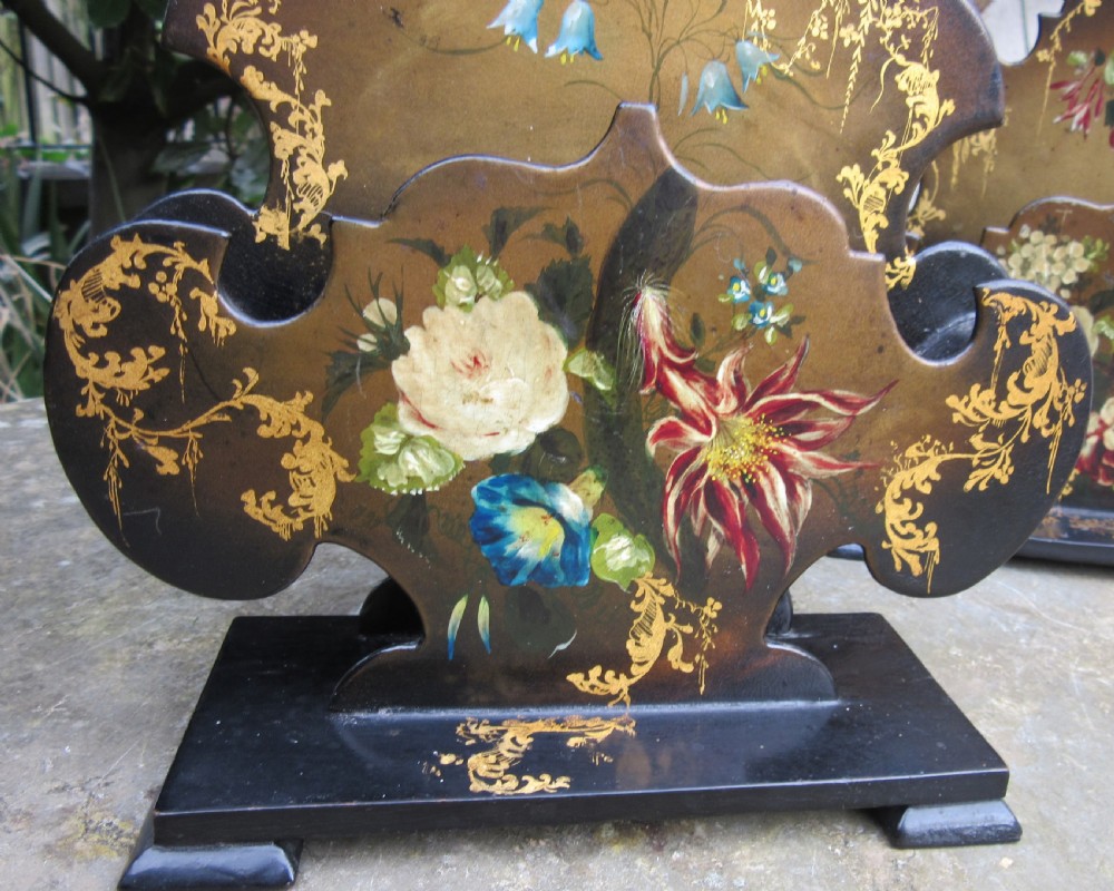 A pair of Regency black papier-mache letter stands decorated with hand-painted floral motifs and gilded foliage on stepped rectangular bases. View VI