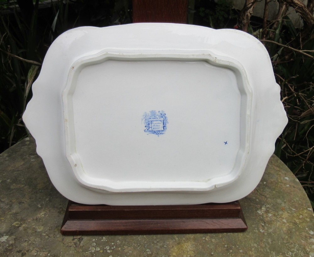 A rectangular blue and white transferware platter decorated with classical statues, buildings, and a sailboat scene with molded side handles. View II
