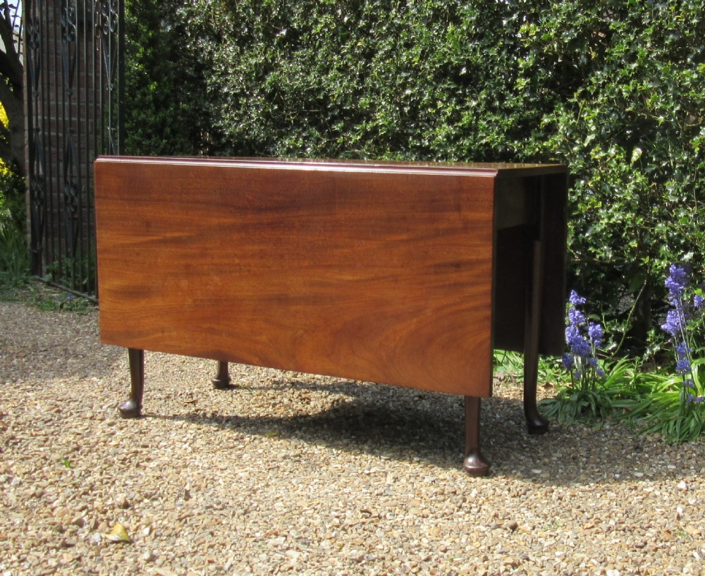 A Georgian mahogany drop-leaf dining table shown with extended leaves and tapered legs ending in pad feet. View II