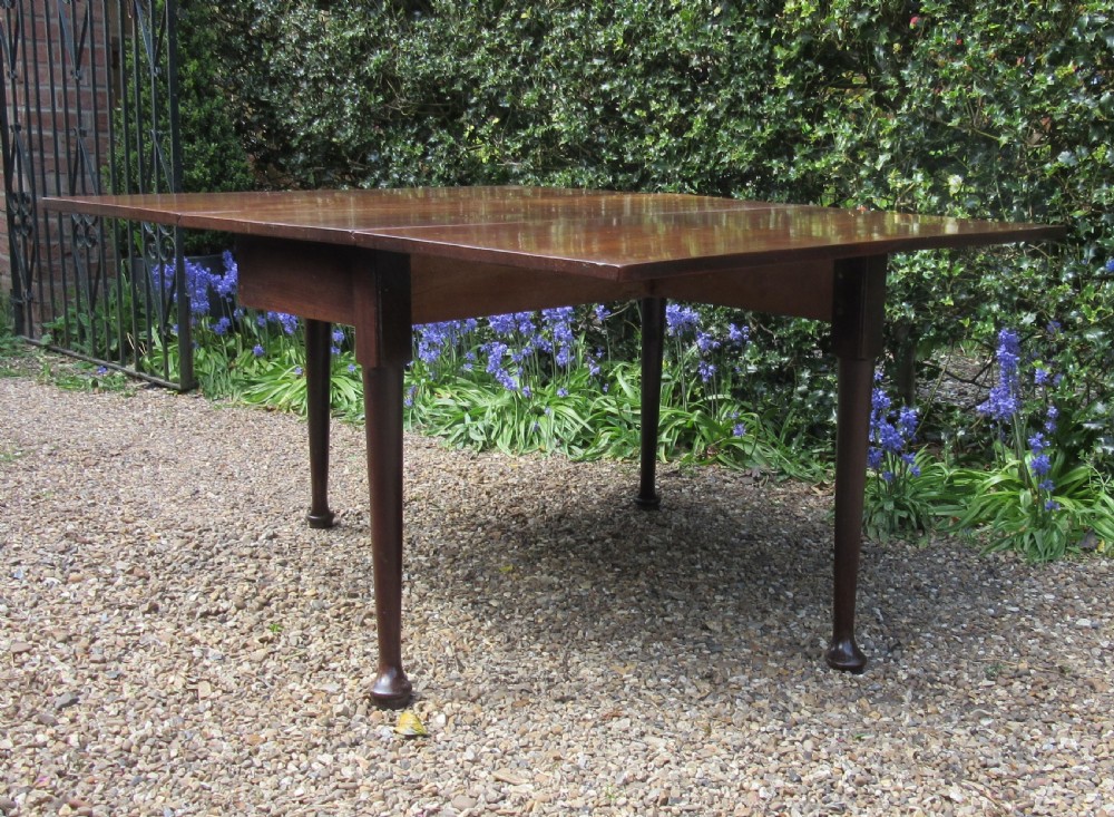 A Georgian mahogany drop-leaf dining table shown with extended leaves and tapered legs ending in pad feet. View III