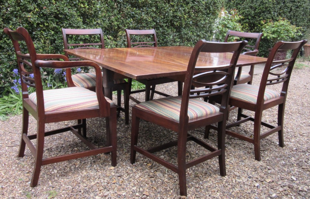 A Georgian mahogany drop-leaf dining table shown with extended leaves and tapered legs ending in pad feet. View IV